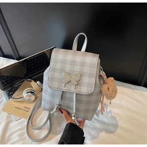 Détail du mini sac à dos à carreaux avec boucle papillon argentée et pendentif ours