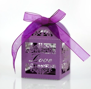 Detail of purple laser-cut wedding candy box with Love lettering and satin ribbon bow