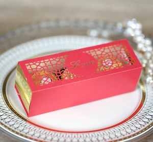 Detail einer roten ausgeschnittenen Geschenkschachtel mit goldener Love-Schrift und Pralinen