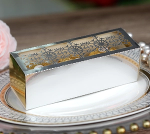 Macro shot of silver mirror gift box with laser-cut snowflake lid and chocolate inside