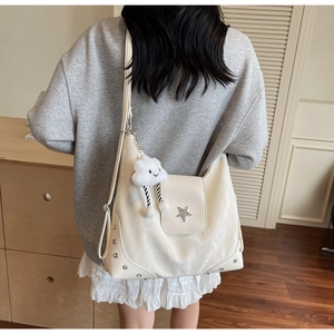 Detail of white Hobo bag with star logo and rivets shown from back view on model