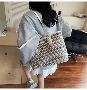 Detail view of a large capacity tote bag with geometric clover print in a lifestyle setting