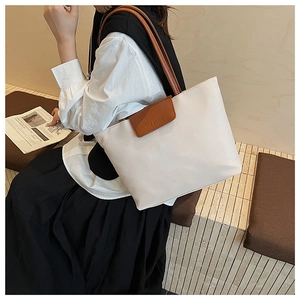 Close-up of the large tote bag with GEE ARGK embossed logo and brown leather straps