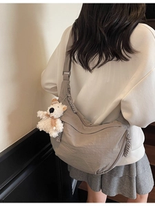 Light gray large nylon dumpling crossbody bag with adjustable strap and bear pendant
