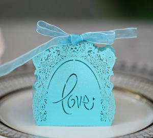 Detail of light blue laser-cut candy box with LOVE lettering and matching ribbon bow