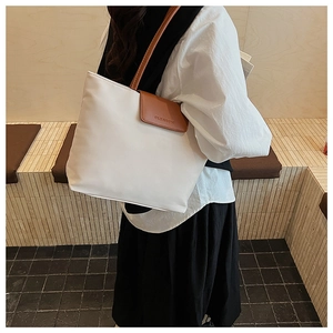 Detail shot of the white canvas tote bag with brown leather handles and CLEAROK logo