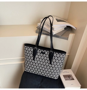 Detail of retro geometric pattern tote bag with black leather straps on white surface