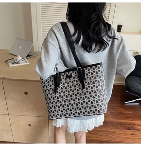 Detail of large tote bag with black and white geometric patterns and adjustable straps