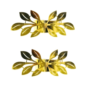 Macro shot of gold leaf-shaped napkin rings with intricate hollow vein design details