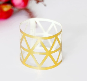 Macro detail of a golden geometric hollow napkin ring with triangular mesh metal design