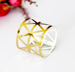 Close-up of golden hollow geometric napkin ring with triangle metal frames for table decor