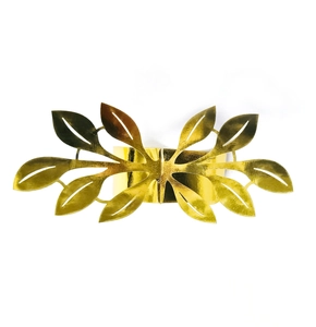 Close-up of golden leaf napkin ring with intricate hollowed-out vein patterns