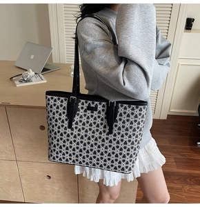 Detail of black and white geometric floral tote bag with adjustable straps in office setting