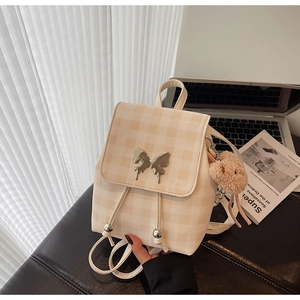 Détail du mini sac à dos à carreaux avec boucle papillon et breloque petit ours