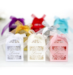 Macro view of laser-cut 'Love' candy boxes with delicate ribbons and floral patterns
