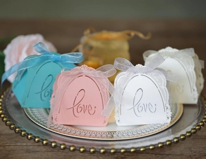 Detailed laser-cut 'Love' candy boxes with lace patterns and ribbon bows in four colors