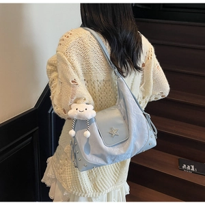Detail of light blue tote with star stud, cloud charm and silver rivet accents
