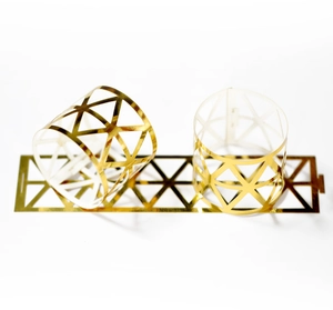 Detailed view of hollow geometric gold napkin rings with shiny metallic mirror finish