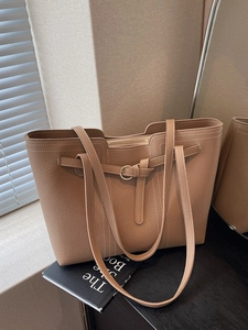 Chic khaki leather tote bag with contrast stitching on elegant scene background
