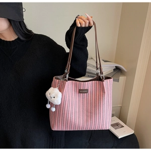Detail of pink chevron woven tote with brown leather handles and a plush cloud charm