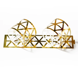 Detail showing the geometric triangular hollow design of a shiny gold napkin ring