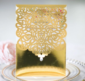 Macro shot of gold laser-cut rose hollow invitation card with reflective finish details