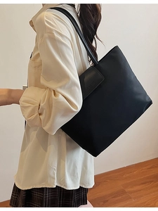 Minimalist black leather tote bag for women showing a stylish commute look with large capacity