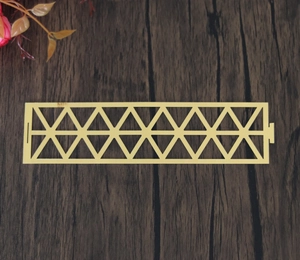 Macro detail of gold geometric triangle pattern cutout decorative napkin ring strip