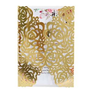 Détail d'invitation de mariage dorée découpée au laser avec motifs de roses et carte blanche