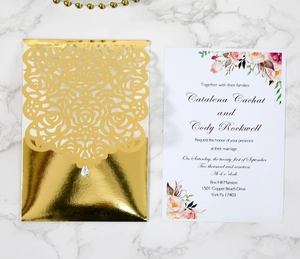 Detail of laser-cut gold metallic wedding invitation cover with rose floral patterns