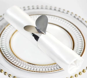 Gros plan du rond de serviette en papier en forme de cœur sur une serviette lors d'un mariage