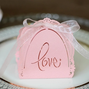 Pink laser-cut wedding favor box with Love text, lace trim and white ribbon detail