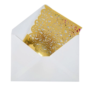 Detailed laser-cut gold rose pattern on card with a white minimalist v-flap envelope