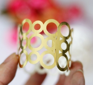 Détail d'un rond de serviette doré géométrique aux cercles évidés pour décoration de fête