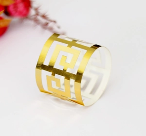 Vue détaillée du rond de serviette doré à motif grec avec finition miroir brillante