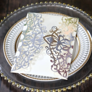 Detail view of laser cut wedding invitation card with holographic foil on a decorative plate