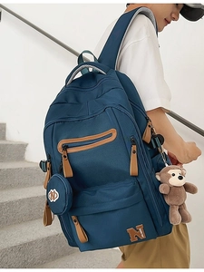 Navy blue large capacity travel backpack for students with brown monkey plush pendant