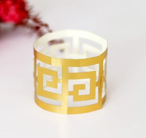 Détail d'un rond de serviette en papier doré découpé au laser pour décoration de mariage