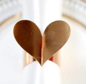 Vue macro d'un rond de serviette en forme de cœur or rose pour décoration de mariage