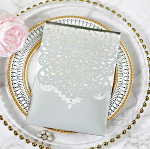 Close-up of laser-cut silver rose hollow invitation card with crystal teardrop detail