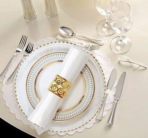 Close-up of golden hollow pattern napkin ring on ivory bone china dinner plate