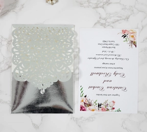 Detail of silver laser-cut rose invitation cover with floral printed card insert