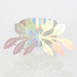 Macro detail of laser-cut leaf napkin ring featuring iridescent holographic finish