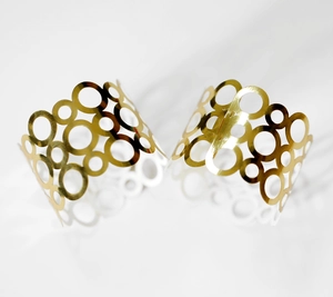 Gros plan de ronds de serviette dorés géométriques au design moderne de cercles superposés