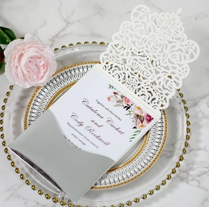 Detail of laser-cut rose invitation with white watercolor floral card and silver mirror sleeve