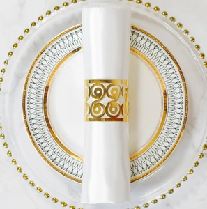 Close-up of golden hollow spiral napkin ring on a white napkin for wedding decor