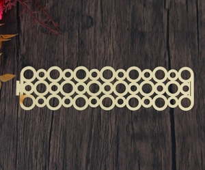 Détail du gabarit de rond de serviette doré découpé au laser avec motif de cercles