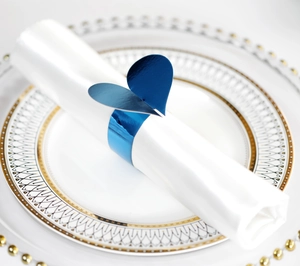 Vue macro d'un élégant rond de serviette coeur bleu sur assiette en porcelaine pour mariage
