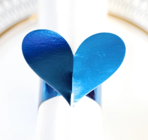 Vue macro d'un rond de serviette bleu en forme de cœur avec finition miroir réfléchissante