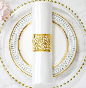 Nahaufnahme des goldenen Serviettenrings mit Rebenmuster auf einem Hochzeitstisch